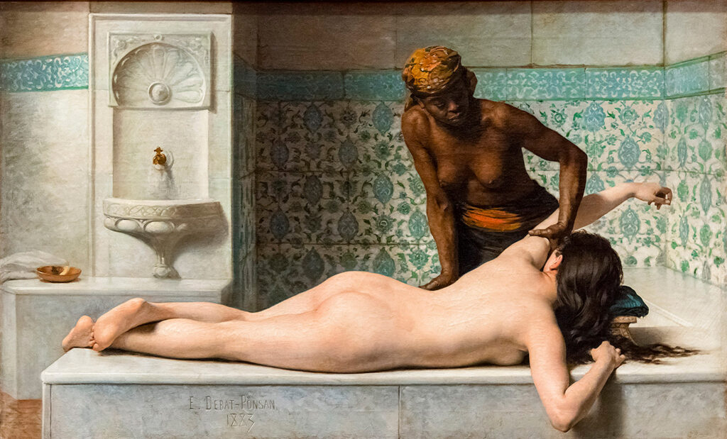 a woman receives a massage in a temple bath setting