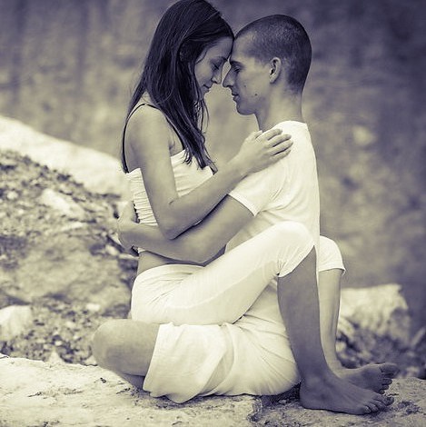 Adult couple seated in Yab Yum meditation with foreheads touching.
